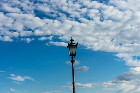 old vintage light pole and sky with cloudsの写真素材