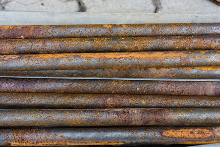 rusty metal pipes for construction and industrial use laying on heapの写真素材