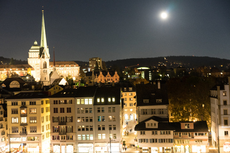 zurich city by night with full moon shinging and light on buildingsの写真素材