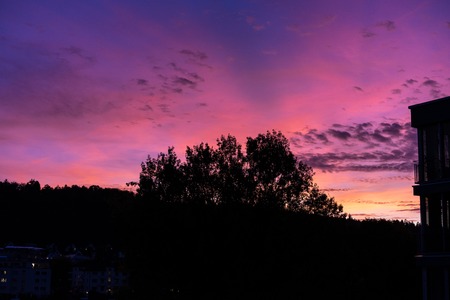 red violet sunset sky with house and treeの写真素材