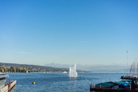 fountain on lake zurich with mountain view in summerの写真素材