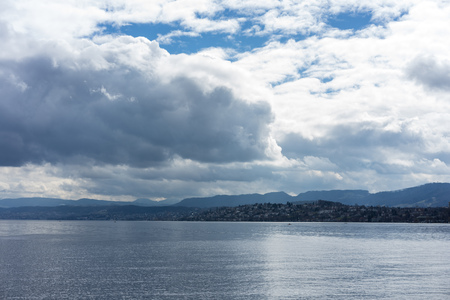 stormy clouds and calm water over lake zurich in switzerlandの写真素材