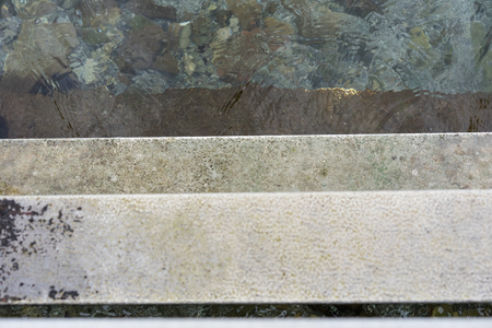 Descend grey concrete stairs into the water, concept photographyの写真素材