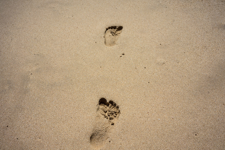 holiday feeling concept, beach sand and foot stepsの写真素材