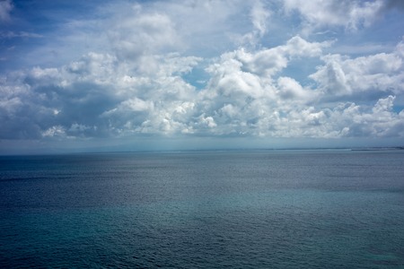 horizon view of coean with blue water and white cloudsの写真素材
