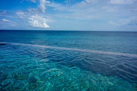 Infinity pool with blue ocean backgroundの写真素材