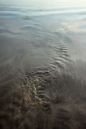 Beach sand water texture detail with small waves
