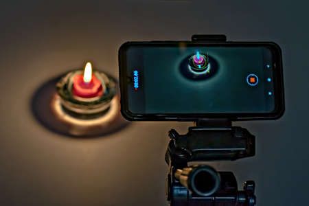 Pune,Maharashtra,India-May 31st,2020:Recording of video of diya on cell phone mounted on tripod.
