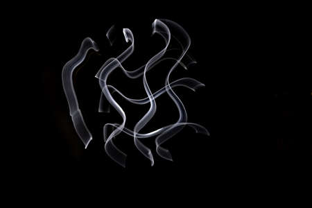 Unique, long exposure, white Led light painting photograph of abstract pattern on black background.の写真素材