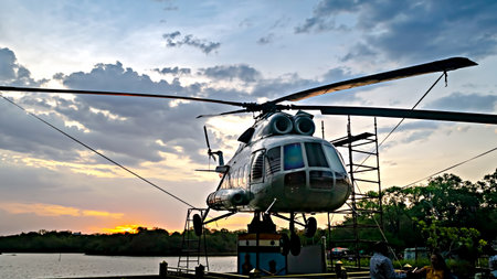 Nagpur, Maharashtra, India-June 12th, 2023: Used military helicopter installed for display near lake with nice sunset in the background.のeditorial素材