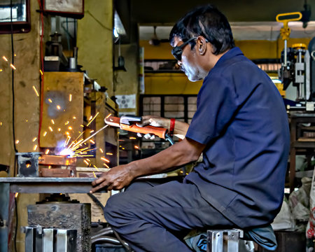 Pune, Maharashtra, India-May 28th, 2023: Skilled operator doing electrode welding work in a small industry.のeditorial素材