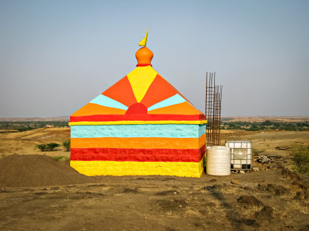 Colorful isolated image of a colorful temple in construction, on the background of nice blue sky in the outskirts of village.の写真素材