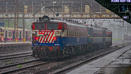 Karjat, Maharashtra, India-June 22nd, 2022: Under very heavy rains, banking locomotive set moves slowly through Karjat railway station.の写真素材