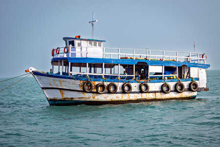 Passenger ferry boat floating on calm sea under clear blue sky, India.の写真素材
