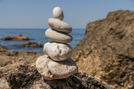 Pebbles stacked up in a pyramid on the sea shore