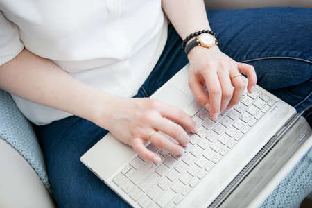 hands of a young girl working with a gadget, working on a laptop, bright colors