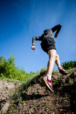 young adult sports guy trail runner practicing sunny day in the mountainsの写真素材
