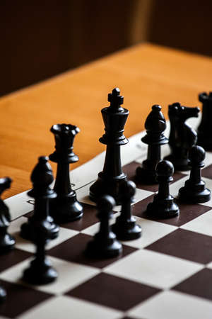 black chess pieces on the board in contour light