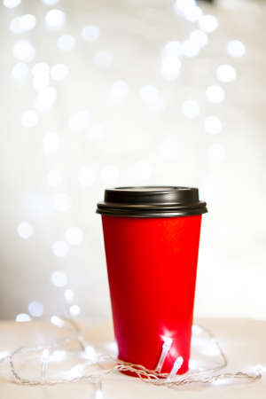 red paper cup for coffee flying in the air against the background of New Year's lighting bokehの写真素材