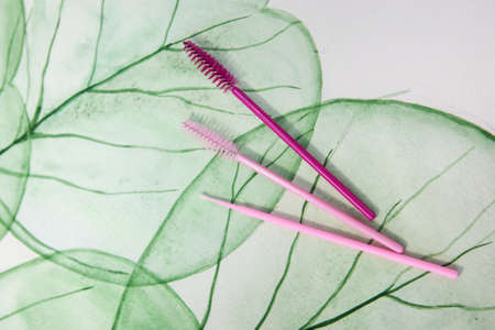 tools for eyelash extensions in hands on a background with a natural patternの写真素材