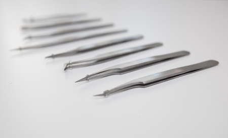 tools for eyelash extension and eyebrow design. cosmetic tweezers in silver color on a white backgroundの写真素材