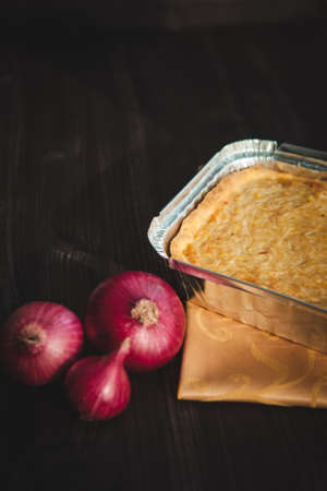 french onion cake on dark wooden background with red onions