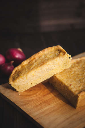 french onion cake on dark wooden background with red onionsの写真素材