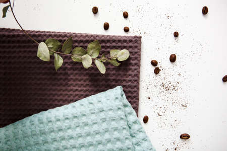 spa and relaxation towels, brown and green towels on a white background with a branch of eucalyptusの写真素材