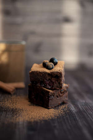 brownie cake on a dark background decorated with fresh berriesの写真素材