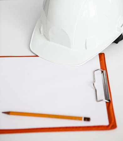 white constructionhelmet on a white background, notepad and pencilの写真素材