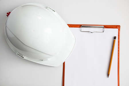 white constructionhelmet on a white background, notepad and pencilの写真素材