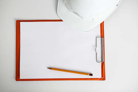 white constructionhelmet on a white background, notepad and pencilの写真素材