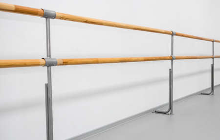 ballet barre in a studio with white walls. An empty ballet class, white walls, and a light wood barの写真素材
