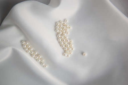 Pearls and nacreous beeds on silk or satin as wedding backgroundの写真素材