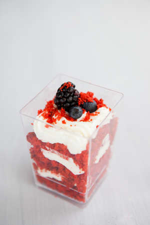 homemade portioned dessert red velvet decorated with berries on a light wooden backgroundの写真素材