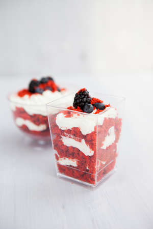 homemade portioned dessert red velvet decorated with berries on a light wooden backgroundの写真素材