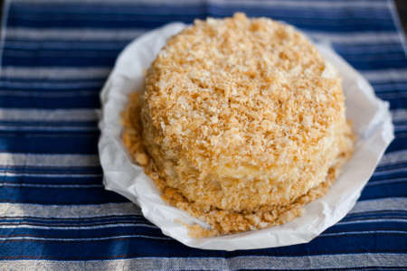 homemade napoleon cake decorated with crumbs on a dark background