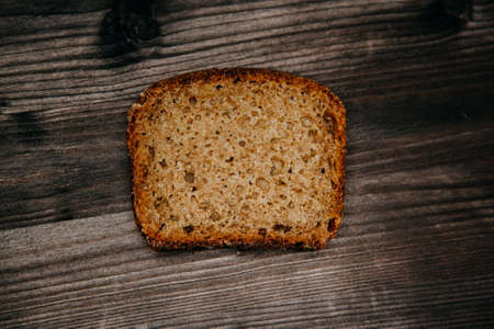 freshly baked black rye bread on a dark background. Dark moody background with free text space. top...