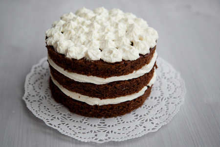 classic homemade cake with chocolate and white cream on a light background