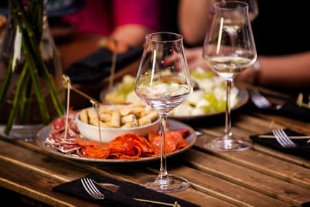 large rustic table on a garden terrace prepared for a dinner party at nightの写真素材
