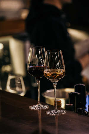 wine glasses and bottles of wine in the entourage of the wine bar in the eveningの写真素材