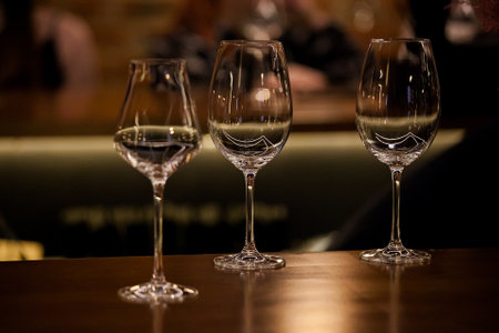wine glasses and bottles of wine in the entourage of the wine bar in the eveningの写真素材