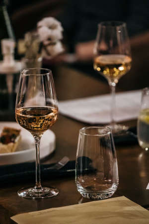 wine glasses and bottles of wine in the entourage of the wine bar in the eveningの写真素材