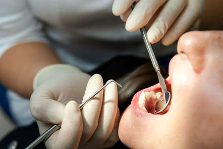 dentist a young white woman examines a patient a young white woman in a dental chairの写真素材