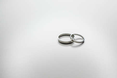 classic wedding rings made of white metal on a white backgroundの写真素材