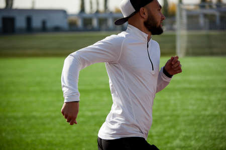 a white man in black shorts and white running at the stadium. workoutの写真素材