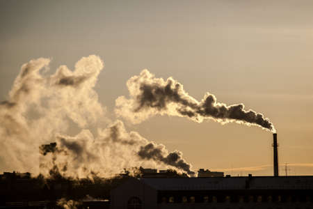 steam from the boiler room pipes in the contoured light of dawn, urban landscape. Smoke from the...