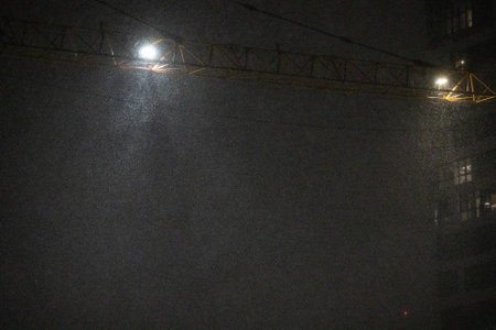 Construction site with large crane in the evening in snowy weatherの写真素材