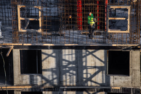 building under construction and workers on a cold day, steam, frame, contrasting light
