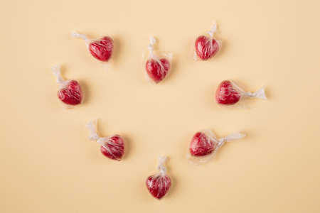 Minimal concept of hearts in the plastic bag making one large heart shape on a pastel yellow...